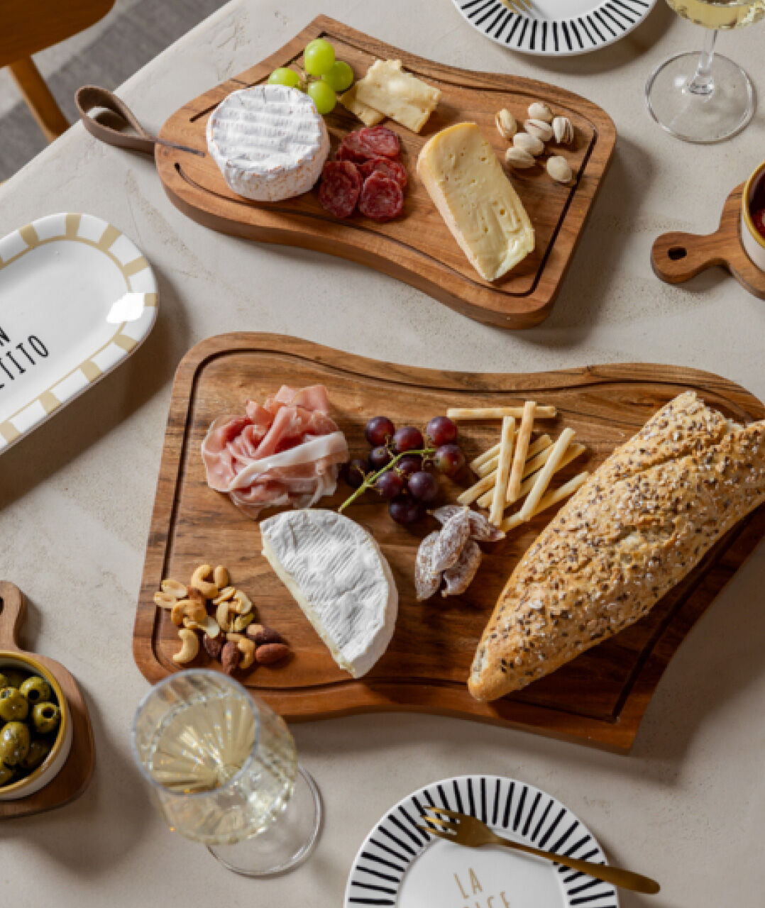 Een tafel 2 borrelplanken met daar kaas, worst en brood op