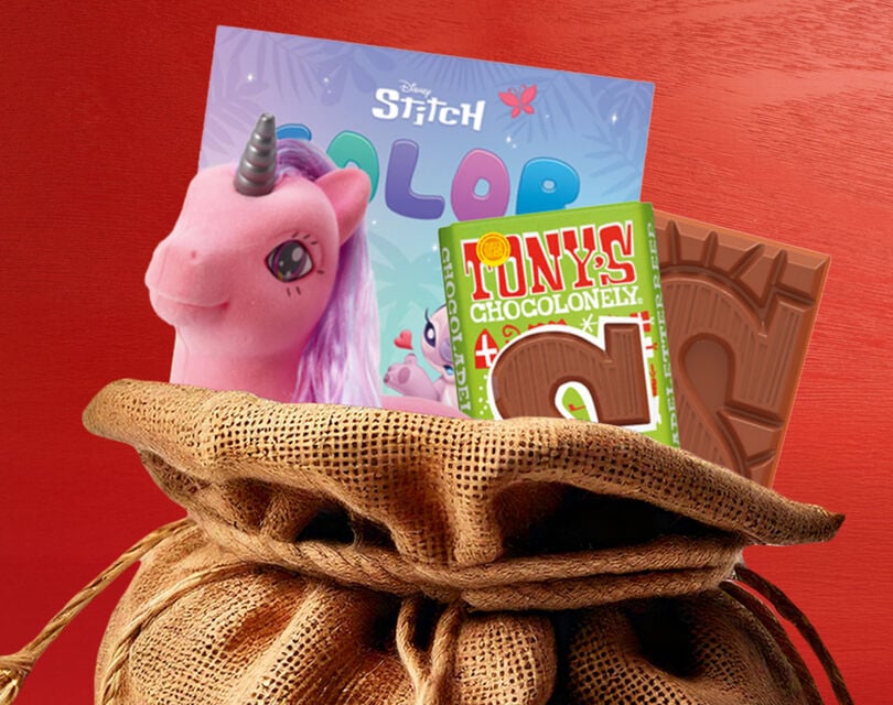 Een jute zak waar Sinterklaas cadeautjes uitpuilen met onder andere tony's chocolonely, een eenhoorn en een Stitch tekenboek