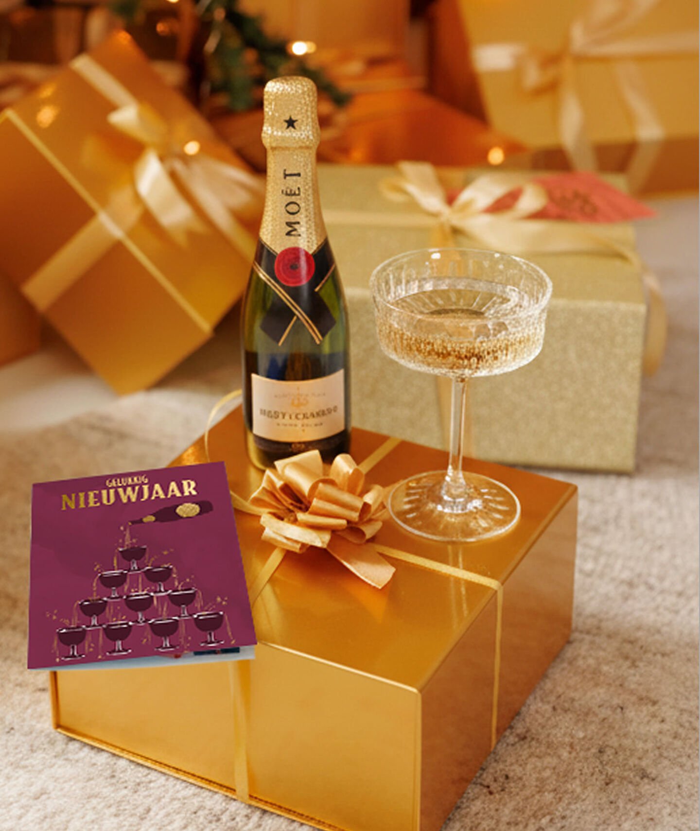 Een glas champagne en fles Mo&euml;t op een gouden pakje