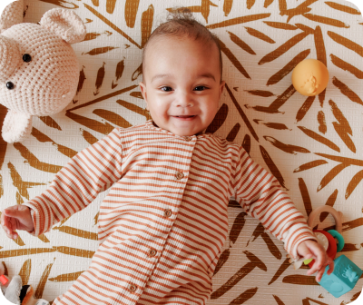 Een baby die op een speelkleed ligt