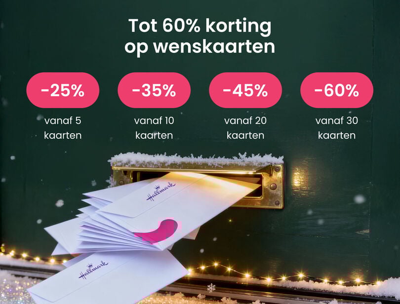 Gestapelde enveloppen met kaarten in de gleuf van een groene brievenbus met gouden lampjes. 