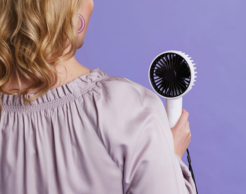 Een vrouw die een hand ventilator vasthoud