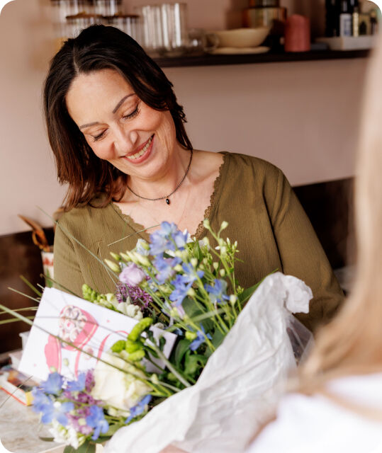 Een vrouw met een bos bloemen in haar handen