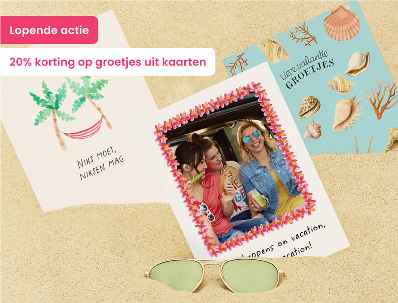 Lopende actie 20% korting op groetjes uit kaarten waarbij kaarten in het zand liggen