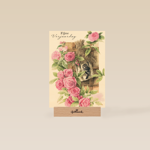 vogel in vogelhuisje tussen rozen